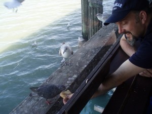An interesting feature of the Santa Maria restaurant is that you can feed the catfish directly from your table.  Apparently pigeons and sea gulls learned about this neat food hand-out station too!  In this shot, Jason feeds the 'fish'.
